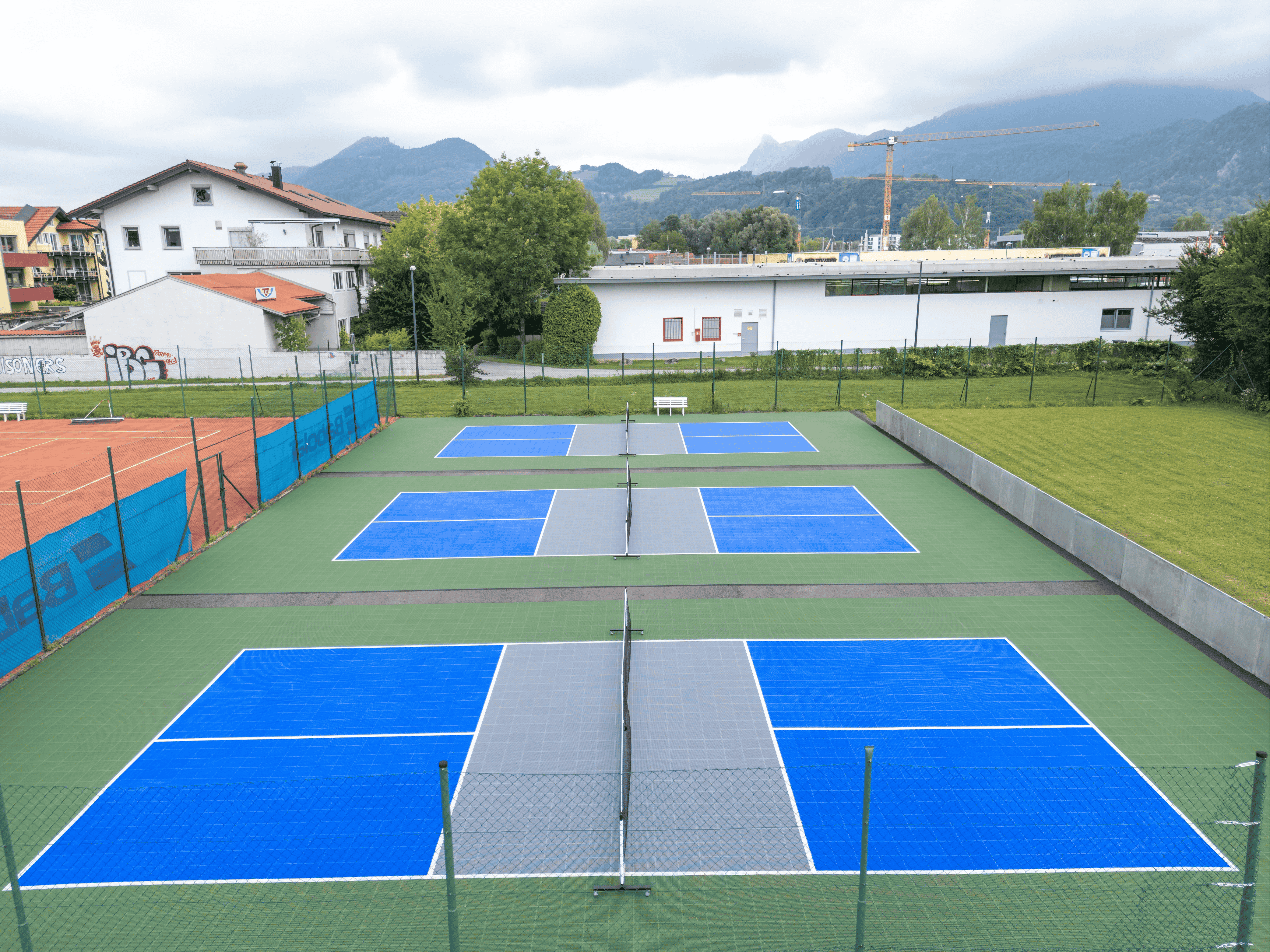 Pickleball-Anlage in Salzburg-Schallmoos mit blauen Plätzen und Bergblick