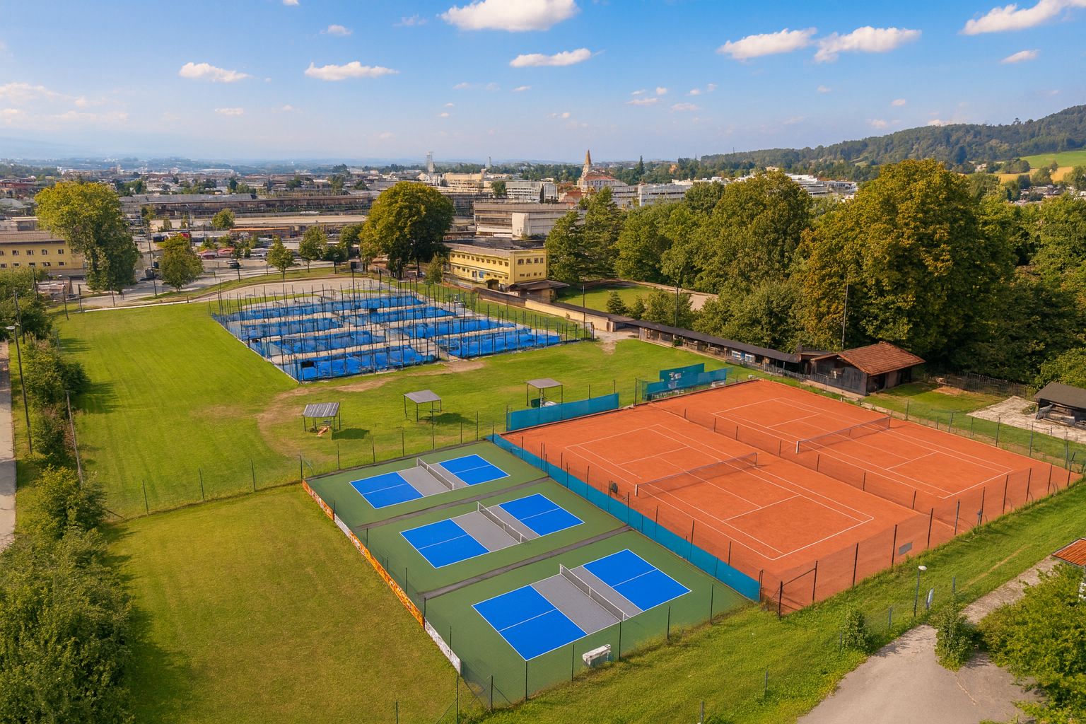 Outdoor-Pickleball-Anlage von Picklepower in Salzburg-Schallmoos mit blauen Pickleball-Plätzen und Stadtblick